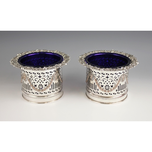 124 - A pair of early 20th century silver plated bottle coasters, each of cylindrical form with lion masks... 