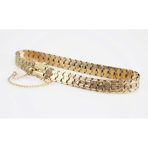 174 - A yellow metal bracelet by Smith & Pepper, the brick link chain with engraved foliate detail,  tongu... 