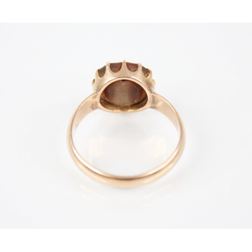 179 - An early 20th century gold coloured shell set ring, the central circular shell panel measuring 12mm ... 