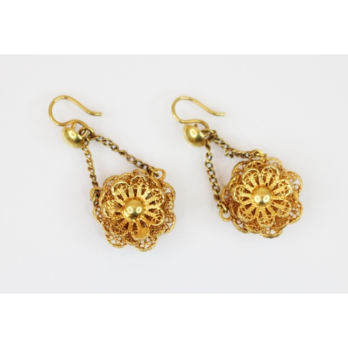 218 - A pair of yellow metal floral filigree drop earrings, each dropper modelled as a filigree flower hea... 