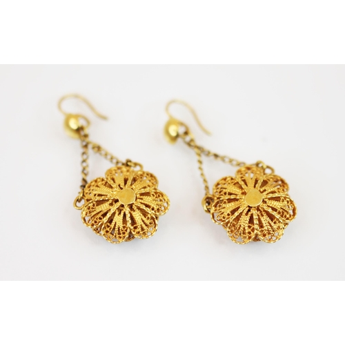 218 - A pair of yellow metal floral filigree drop earrings, each dropper modelled as a filigree flower hea... 