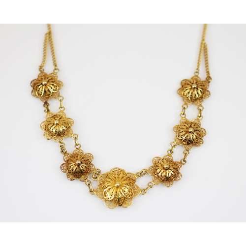 222 - A yellow metal floral filigree necklace, the front section designed as seven graduated gold coloured... 