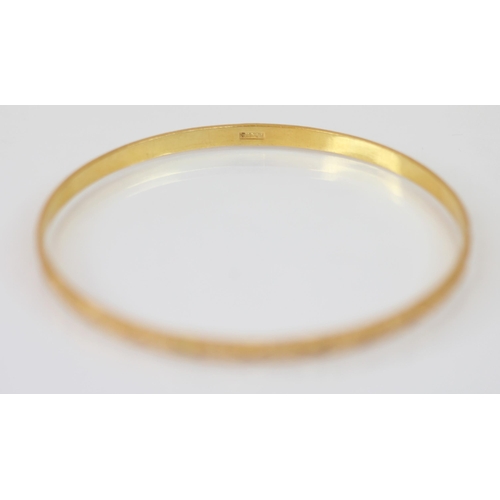 224 - A Middle Eastern gold coloured bangle, with etched star decoration to exterior, Arabic character mar... 