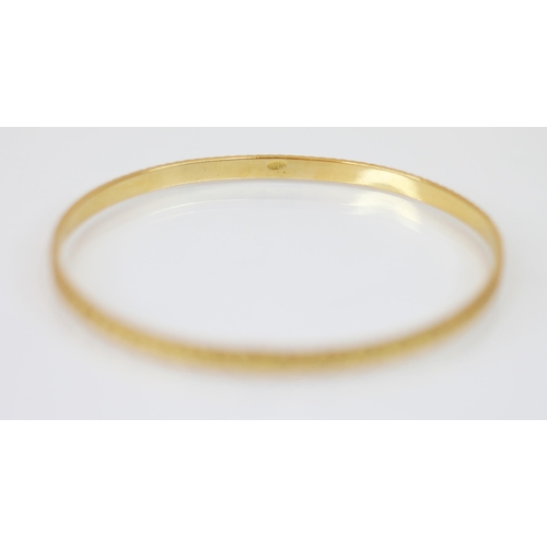 225 - A Middle Eastern gold coloured bangle, with etched circular decoration to exterior, Arabic character... 