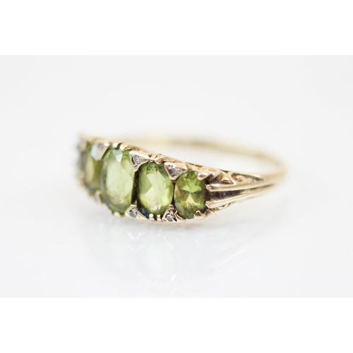 228 - A 9ct gold peridot five stone ring, the ring with central oval mixed cut peridot measuring 6.48 x 4.... 