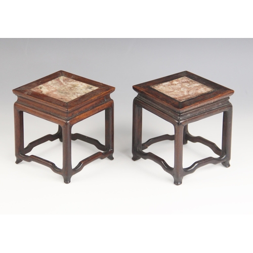 575 - A pair of Chinese carved hard wood marble inset vase stands, each of square section inset with rouge... 