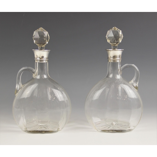 71 - A pair of Edwardian silver collared glass decanters, each of compressed ovoid form with star-cut bas... 