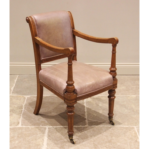 835 - A Victorian honey oak/leather library chair, the padded back rest on reeded uprights below roundel t... 