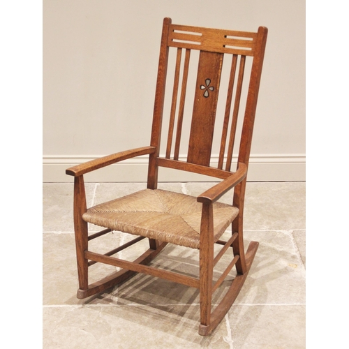 850 - An oak Arts & Crafts rocking chair in the manner of Heals, early 20th century, the pierced angular t... 