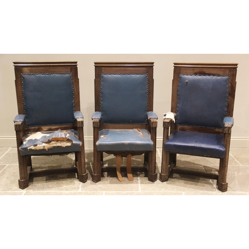 866 - A trio of teak and leather magistrates court throne chairs, early 20th century, each with a moulded ... 