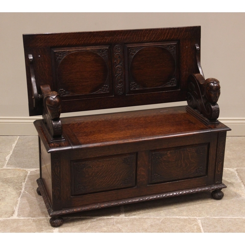 869 - A 17th century style oak monks bench, 20th century, the panelled tilt top upon supports carved with ... 