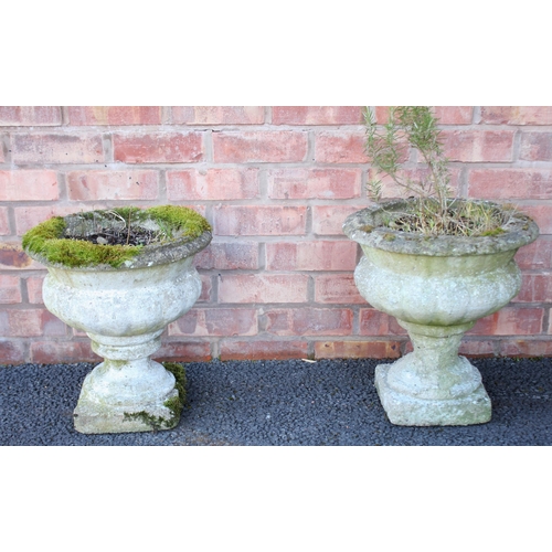 885 - A pair of reconstituted stone garden planters, of lobed urn form, upon integral plinth bases, 41cm h... 