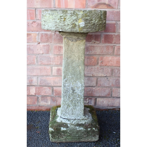 886 - A sandstone bird bath, the shallow circular well upon a tapering square section column and plinth ba... 