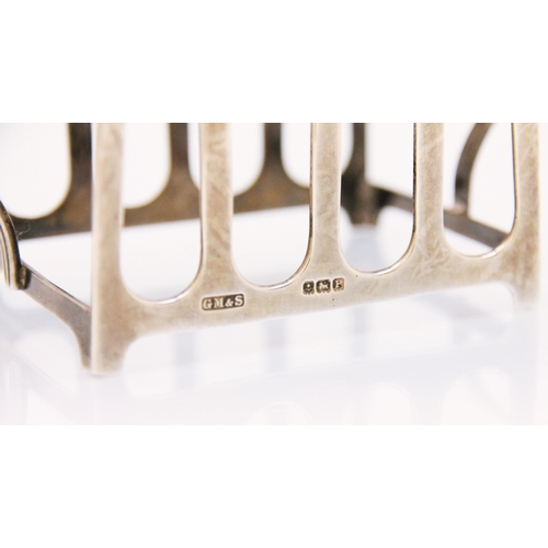 98 - A George VI silver two handled toast rack, G M and S, Birmingham 1939, the four division rack of ang... 