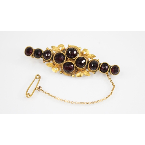 157 - A Victorian garnet set bar brooch, the central cluster comprising four round rose cut garnets, set t... 