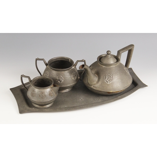 584 - An Arts and Crafts planished pewter three piece part tea service, in the manner of Archibald Knox, t... 