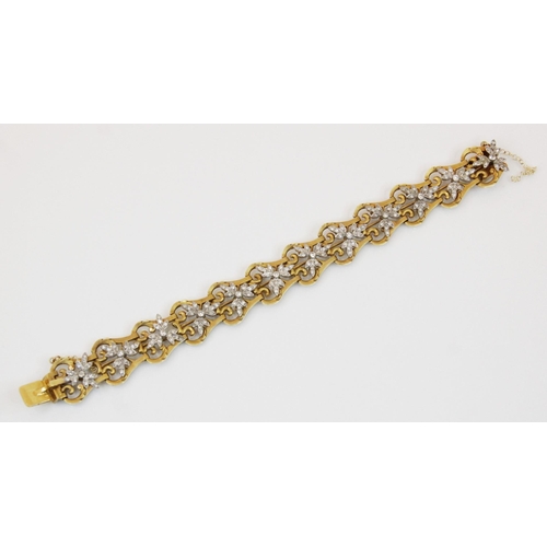 155 - A diamond set bracelet, designed as a row of pierced gold coloured lyre shaped links, with twelve ap... 