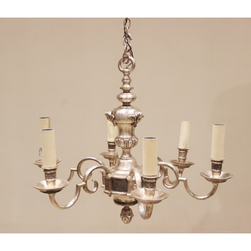 674 - A white metal six branch chandelier, the urn shaped column applied with cast cherub masks, extending... 