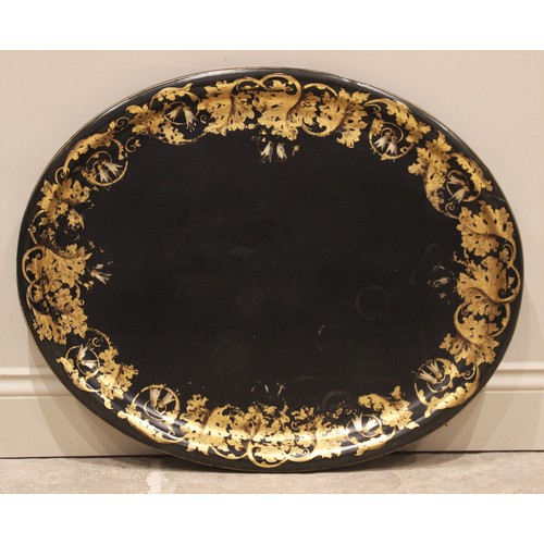 582 - A Victorian papier mache tray, of oval form, the raised moulded rim applied with gilt scrolling foli... 