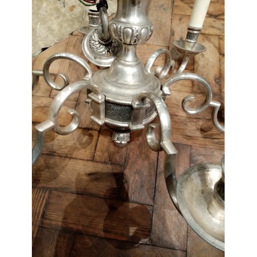 674 - A white metal six branch chandelier, the urn shaped column applied with cast cherub masks, extending... 