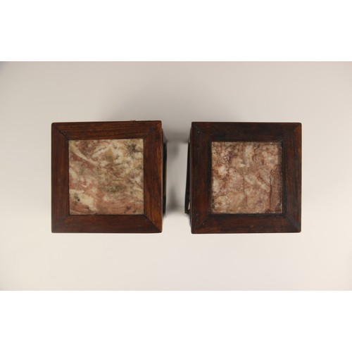 575 - A pair of Chinese carved hard wood marble inset vase stands, each of square section inset with rouge... 