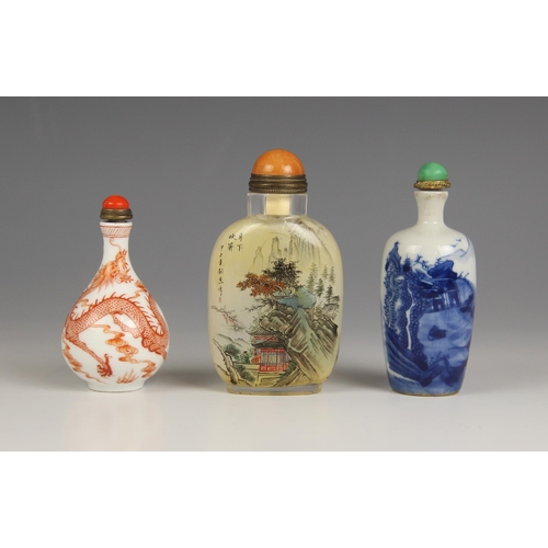 425 - Three Chinese snuff bottles and stoppers, comprising; a reverse painted rounded rectangular example,... 