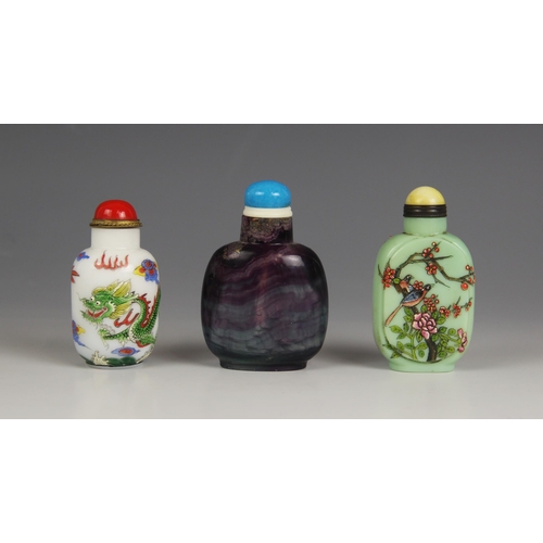 426 - Three Chinese snuff bottles and stoppers, comprising; an amethyst glass example, 8cm high, a Peking ... 