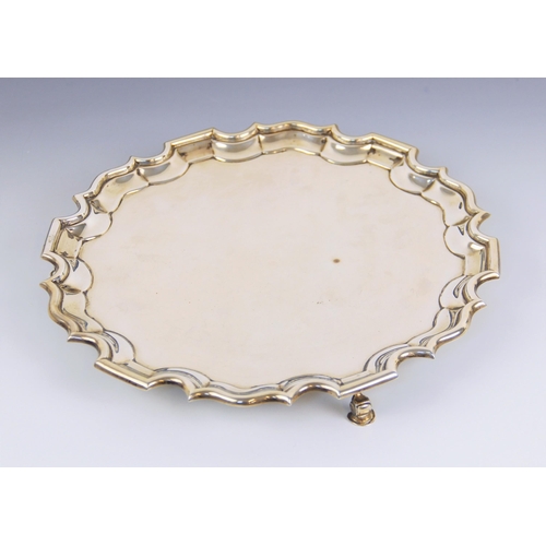 45 - An Edwardian silver salver, William Aitken, Birmingham 1906, with moulded border, upon three scroll ... 