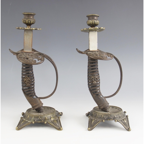 548 - A pair of WWI German sword hilt candlesticks, the hilt guards cast in open relief with an eagle insi... 