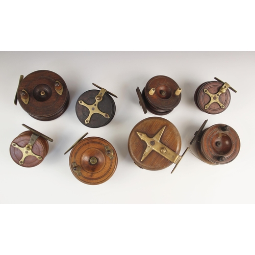 575 - A collection of eight walnut and brass mounted centrepin fishing reels, early 20th century and later... 