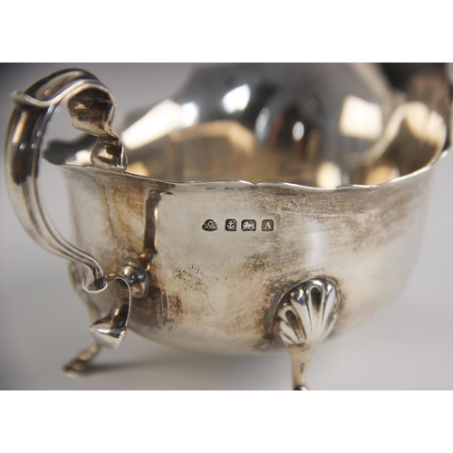 70 - A George V silver sauce boat, Adie Brothers Ltd, Birmingham 1925, with scroll handle upon three shel... 