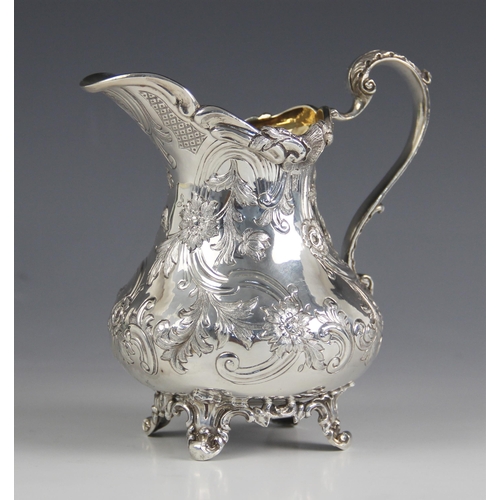 78 - A Victorian silver milk jug, possibly John Wellby, London 1841, the cast foliate rim above an emboss... 