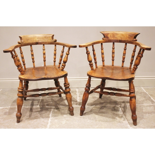 799 - A near pair of Victorian elm and beech smokers bow elbow chairs, each with a horse shoe top rail and... 