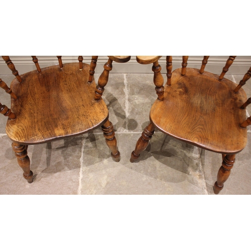 799 - A near pair of Victorian elm and beech smokers bow elbow chairs, each with a horse shoe top rail and... 