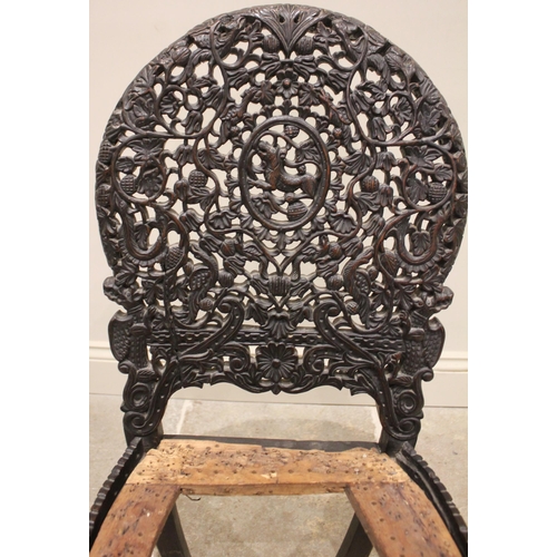 806 - A Ceylonese hardwood chair, late 19th/early 20th century, the arched openwork back rest carved with ... 