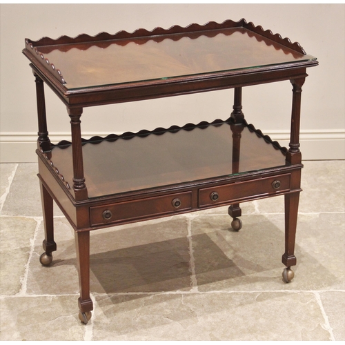 821 - An early 20th century flame mahogany drinks trolley, the upper tier with a three quarter wavy galler... 