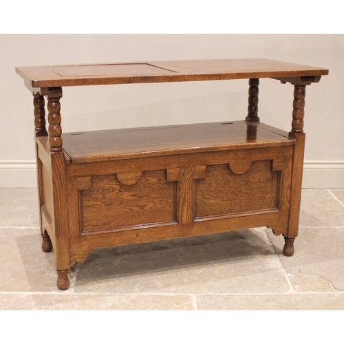 823 - A 17th century style golden oak monks bench, 20th century, the recessed geometric panelled back rest... 