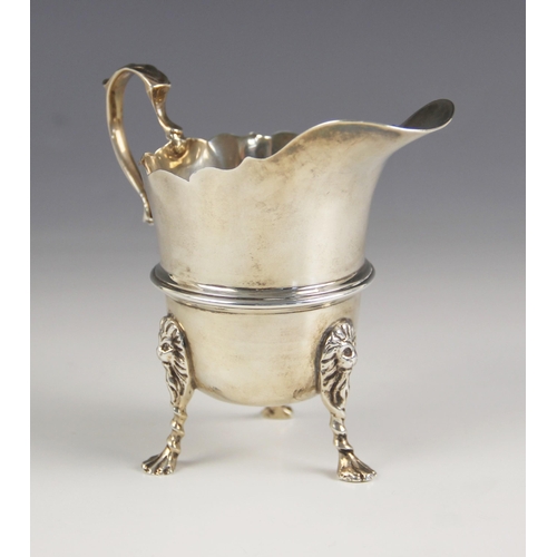 91 - A George V silver cream jug, Wakely & Wheeler, Dublin 1912, in Georgian style, with scroll handle an... 