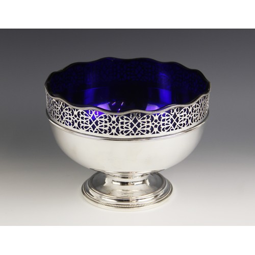 11 - A silver plated fruit bowl, of circular form with pierced scrolling border and waved beaded rim, upo... 