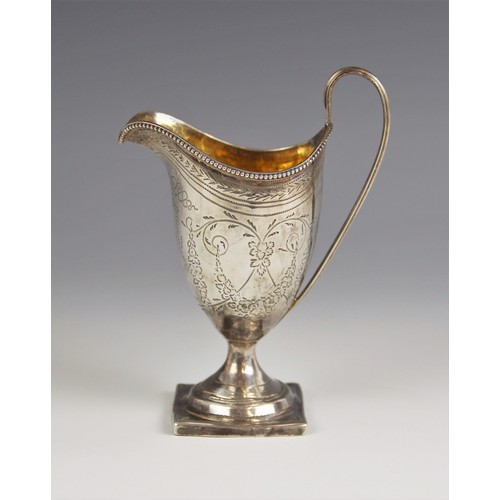 17 - A George III silver cream jug, London 1796, of helmet form on square base with loop handle, chased w... 