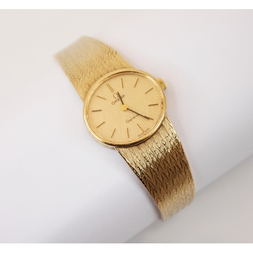 164 - A 9ct yellow gold ladies Omega Geneve wristwatch, the oval textured champagne coloured dial with bat... 