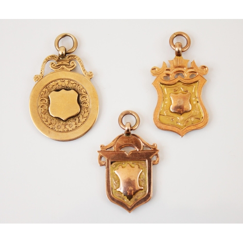 174 - A selection of three 9ct gold fobs, to include a circular example with plain polished central shield... 