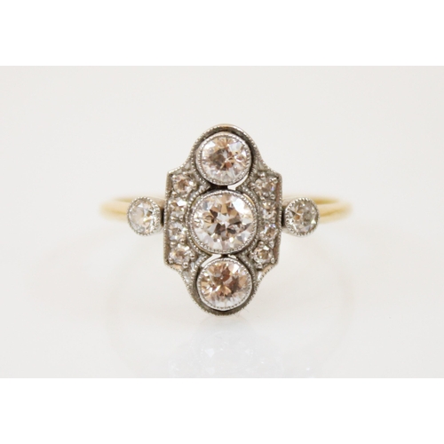 180 - An early 20th century diamond ring, the three central graduated old cut diamonds with a surround of ... 