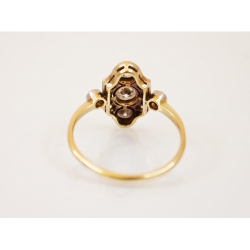 180 - An early 20th century diamond ring, the three central graduated old cut diamonds with a surround of ... 