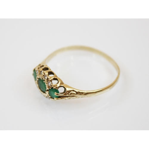 181 - An emerald and diamond 9ct gold ring, the three graduated round cut emeralds within a border of diam... 