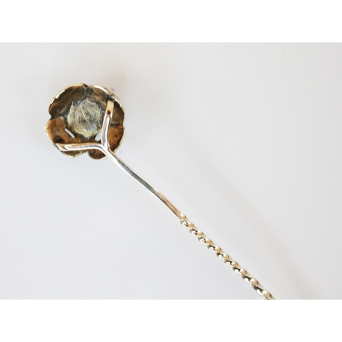 183 - A garnet set yellow metal stick pin, the round cut garnet cut down set within a flower head designed... 