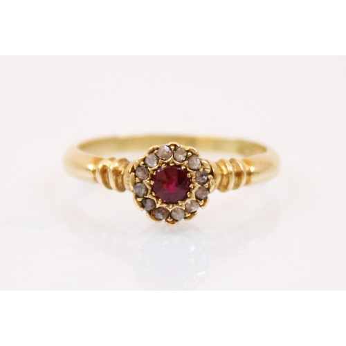 207 - An Edwardian ruby and diamond ring, the central round cut ruby surrounded by a border of diamond chi... 