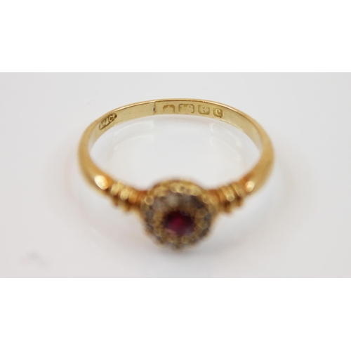 207 - An Edwardian ruby and diamond ring, the central round cut ruby surrounded by a border of diamond chi... 