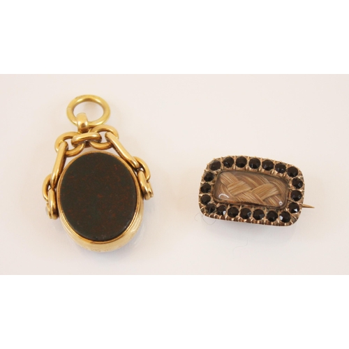 225 - A late 19th century mourning brooch, the central rectangular glazed aperture with plaited hair withi... 