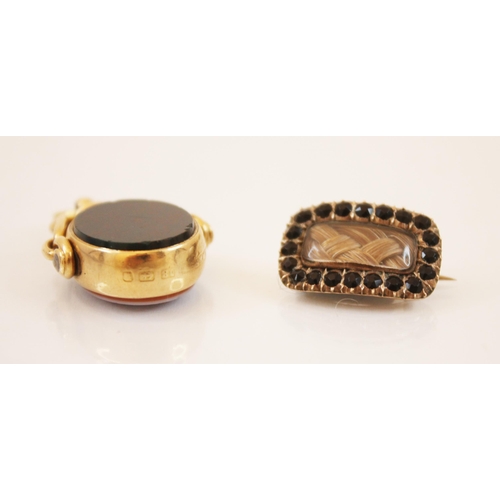 225 - A late 19th century mourning brooch, the central rectangular glazed aperture with plaited hair withi... 